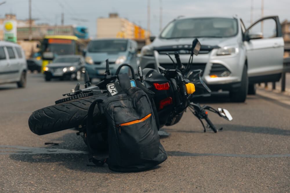 The motorcycle lies on the sidewalk after a ride. Serious accident. Accident, close-up. Lost control and fell. Driving hazards. Collisions with another vehicle.